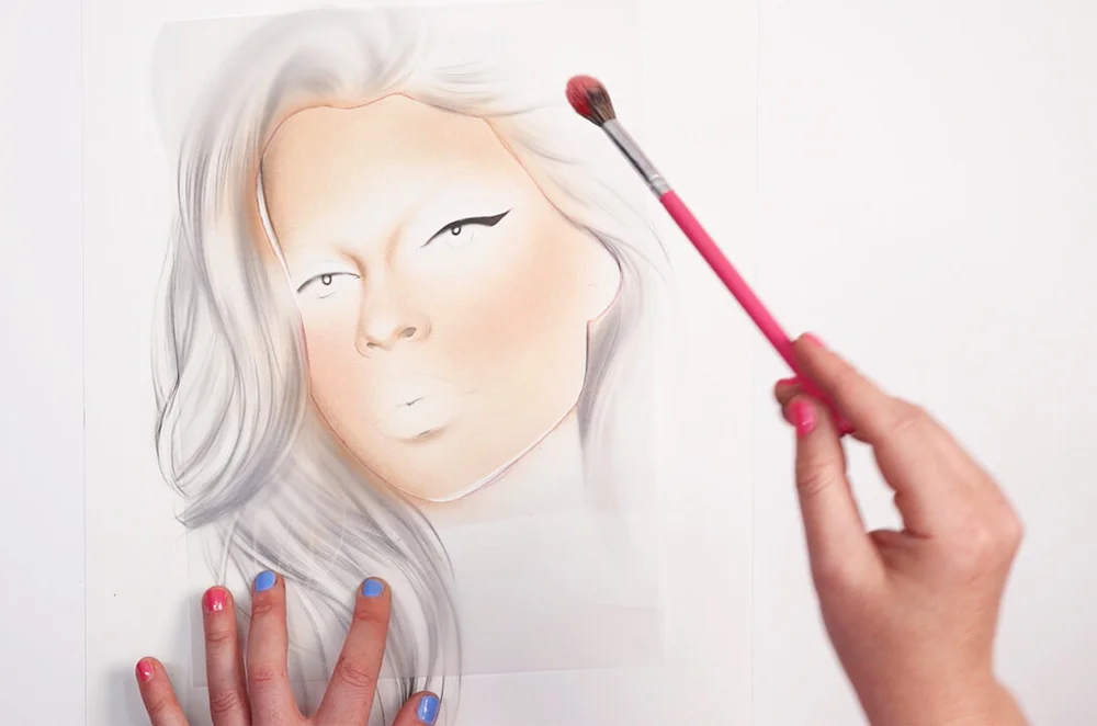 Applying blush on a Kylie Jenner face chart with a small brush